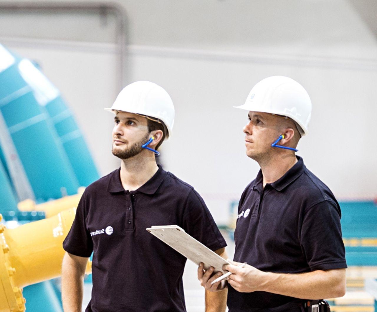 Two Statkraft employees inside the machine hall of Erzhausen pump storage power plant.