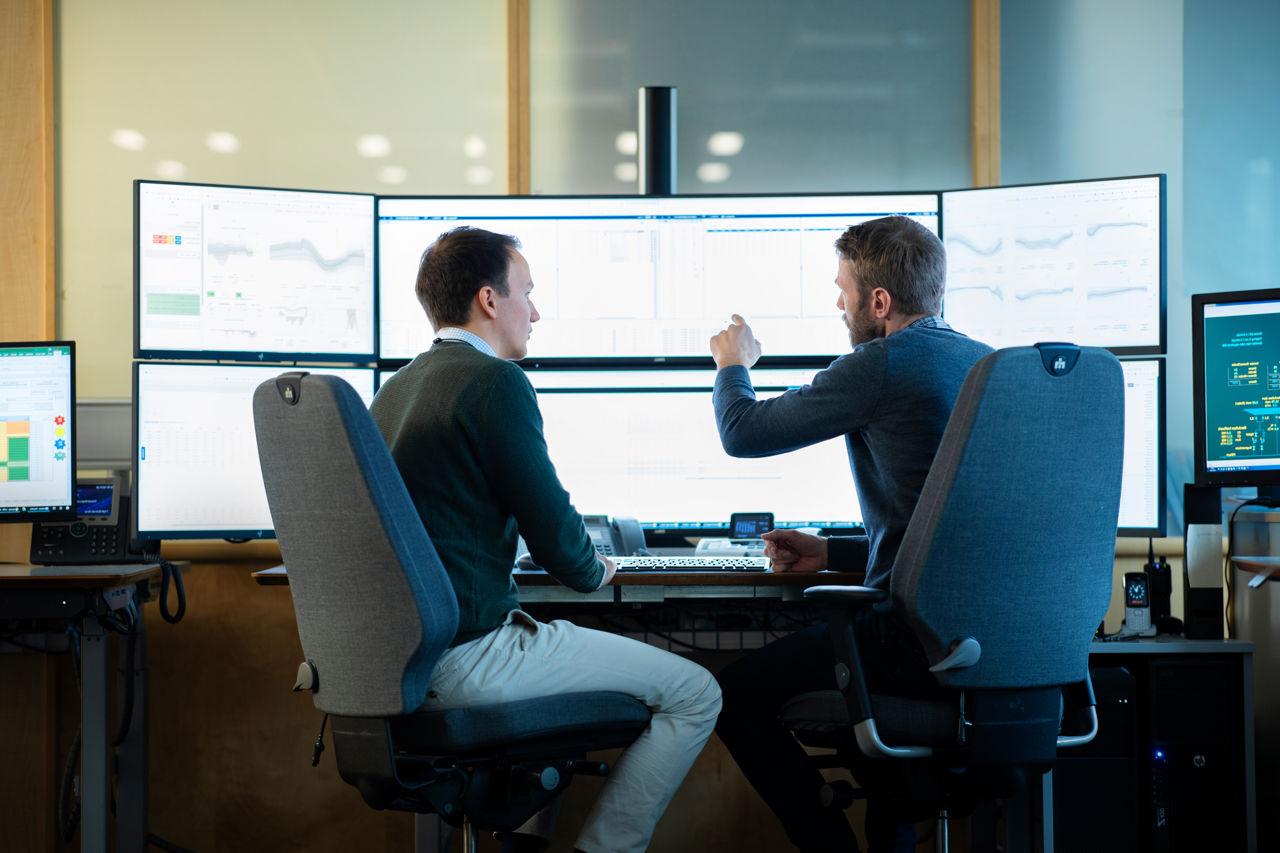 Two traders discussing in front of a computer